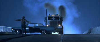 Movie still from “Terminator 2: Judgment Day” (1991), directed by James Cameron – A truck and a car driving down a street; Wide shot, Low angle