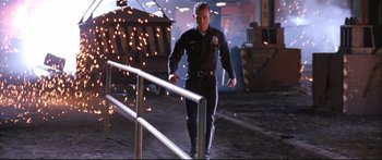 Movie still from “Terminator 2: Judgment Day” (1991), directed by James Cameron – A police officer walking down a street next to a railing; Wide shot, Low angle