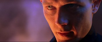 Movie still from “Terminator 2: Judgment Day” (1991), directed by James Cameron – A man's face with a purple light in the background; Extreme Close Up shot, Low angle