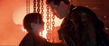 Movie still from “Terminator 2: Judgment Day” (1991), directed by James Cameron – A man and a boy are standing next to each other; Close Up shot, Low angle