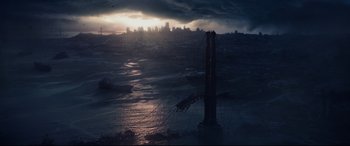 Movie still from “Terminator Genisys” (2015), directed by Alan Taylor – The sun is setting over the ocean with a tower in the middle of the water; Extreme Wide shot, High angle