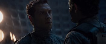 Movie still from “Terminator Genisys” (2015), directed by Alan Taylor – A man standing next to another man in a dark room; Close Up shot, Over the shoulder angle