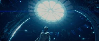 Movie still from “Terminator Genisys” (2015), directed by Alan Taylor – A man standing in a room under a large window; Wide shot, Low angle