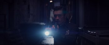 Movie still from “Terminator Genisys” (2015), directed by Alan Taylor – A man holding a gun and a flashlight in a dark room; Medium shot, Low angle