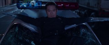 Movie still from “Terminator Genisys” (2015), directed by Alan Taylor – A man in a police uniform sitting in a car; Medium shot, Low angle