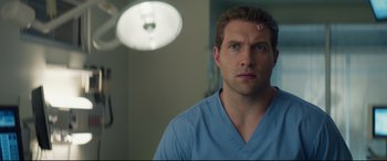 Movie still from “Terminator Genisys” (2015), directed by Alan Taylor – A man in a blue shirt is in a hospital room; Close Up shot, Over the shoulder angle