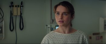 Movie still from “Terminator Genisys” (2015), directed by Alan Taylor – A young woman in a hospital gown looking at the camera; Close Up shot, Over the shoulder angle