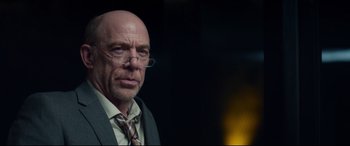 Movie still from “Terminator Genisys” (2015), directed by Alan Taylor – A bald man wearing glasses and a tie; Close Up shot, Over the shoulder angle