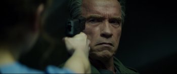 Movie still from “Terminator Genisys” (2015), directed by Alan Taylor – A person holding a gun up to a man's face; Close Up shot, Over the shoulder angle