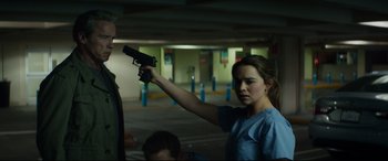 Movie still from “Terminator Genisys” (2015), directed by Alan Taylor – A woman holding a gun in a parking garage; Medium shot, Over the shoulder angle