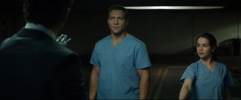 Movie still from “Terminator Genisys” (2015), directed by Alan Taylor – A man wearing a blue shirt and blue scrubs; Medium shot, Over the shoulder angle