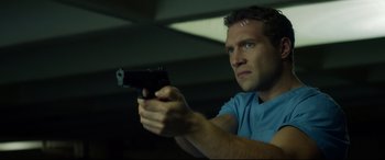 Movie still from “Terminator Genisys” (2015), directed by Alan Taylor – A man is holding a gun in a room; Close Up shot, Low angle