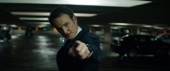 Movie still from “Terminator Genisys” (2015), directed by Alan Taylor – A man in a suit and tie pointing at the camera; Close Up shot, Low angle