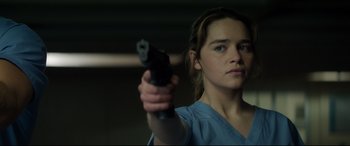 Movie still from “Terminator Genisys” (2015), directed by Alan Taylor – A woman holding a gun while wearing a blue shirt; Close Up shot, Over the shoulder angle