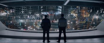 Movie still from “Terminator Genisys” (2015), directed by Alan Taylor – Two men standing in front of a large glass window; Wide shot, Over the shoulder angle