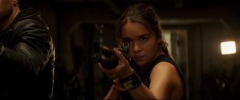 Movie still from “Terminator Genisys” (2015), directed by Alan Taylor – A woman is holding a gun in her hand; Close Up shot, Over the shoulder angle