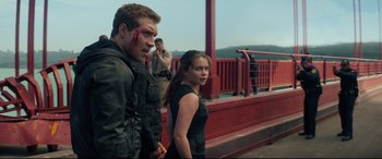 Movie still from “Terminator Genisys” (2015), directed by Alan Taylor – A man and a woman standing next to each other on a bridge; Medium shot, Over the shoulder angle