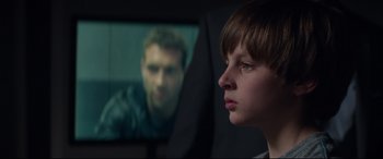 Movie still from “Terminator Genisys” (2015), directed by Alan Taylor – A young boy looking at a man on a television screen; Close Up shot, Over the shoulder angle