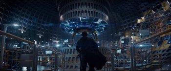 Movie still from “Terminator Genisys” (2015), directed by Alan Taylor – A man standing in front of a building with lights on it; Wide shot, Low angle