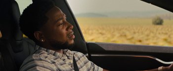 Movie still from “Texas Chainsaw Massacre” (2022), directed by David Blue Garcia – A man sitting in the driver's seat of a car; Close Up shot, Over the shoulder angle