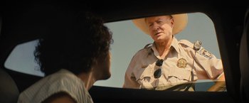 Movie still from “Texas Chainsaw Massacre” (2022), directed by David Blue Garcia – An older man wearing a hat looking in a mirror; Close Up shot, Over the shoulder angle
