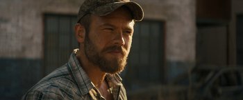 Movie still from “Texas Chainsaw Massacre” (2022), directed by David Blue Garcia – A person with a beard wearing a hat; Close Up shot, Over the shoulder angle