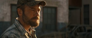 Movie still from “Texas Chainsaw Massacre” (2022), directed by David Blue Garcia – A person with a beard wearing a hat; Close Up shot, Over the shoulder angle