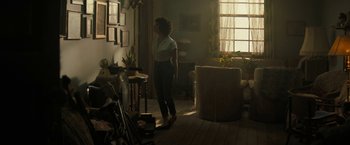 Movie still from “Texas Chainsaw Massacre” (2022), directed by David Blue Garcia – A woman standing in a living room in front of a window; Wide shot, Low angle