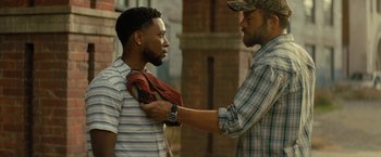 Movie still from “Texas Chainsaw Massacre” (2022), directed by David Blue Garcia – A man helping another man put on a jacket; Medium shot, Over the shoulder angle