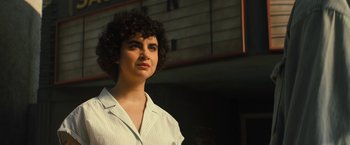 Movie still from “Texas Chainsaw Massacre” (2022), directed by David Blue Garcia – A woman with curly hair standing in front of a building; Close Up shot, Low angle