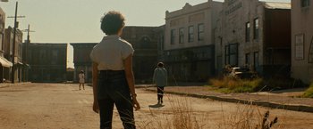 Movie still from “Texas Chainsaw Massacre” (2022), directed by David Blue Garcia – Two people walking down a street in a city; Wide shot, Low angle
