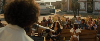 Movie still from “Texas Chainsaw Massacre” (2022), directed by David Blue Garcia – A group of people sitting on top of a wooden bench; Wide shot, Over the shoulder angle