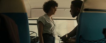 Movie still from “Texas Chainsaw Massacre” (2022), directed by David Blue Garcia – A woman standing in front of a man holding a cell phone; Medium shot, Over the shoulder angle