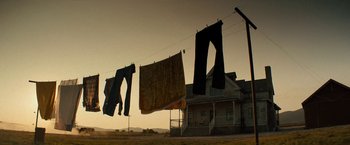 Movie still from “Texas Chainsaw Massacre” (2022), directed by David Blue Garcia – Clothes are hanging on a clothes line outside a house; Wide shot, Low angle