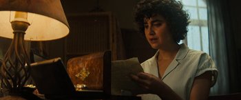 Movie still from “Texas Chainsaw Massacre” (2022), directed by David Blue Garcia – A woman is reading a piece of paper in front of a fireplace; Close Up shot, Over the shoulder angle