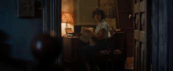 Movie still from “Texas Chainsaw Massacre” (2022), directed by David Blue Garcia – A woman sitting on a chair in front of a desk; Medium shot, Over the shoulder angle