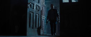 Movie still from “Texas Chainsaw Massacre” (2022), directed by David Blue Garcia – A man holding a gun standing in front of an open door; Wide shot, Low angle