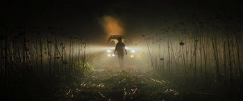 Movie still from “Texas Chainsaw Massacre” (2022), directed by David Blue Garcia – A man standing in a field at night with headlights on; Wide shot, Low angle
