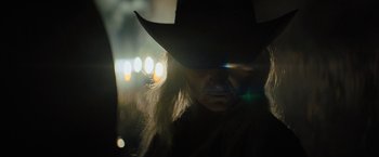 Movie still from “Texas Chainsaw Massacre” (2022), directed by David Blue Garcia – A man in a cowboy hat with lights in the background; Close Up shot, Low angle