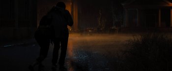Movie still from “Texas Chainsaw Massacre” (2022), directed by David Blue Garcia – A person standing in the rain with a backpack; Wide shot, Low angle