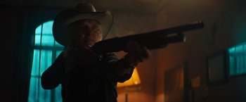 Movie still from “Texas Chainsaw Massacre” (2022), directed by David Blue Garcia – A man in a cowboy hat is holding a gun; Medium shot, Low angle