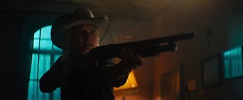 Movie still from “Texas Chainsaw Massacre” (2022), directed by David Blue Garcia – An older man in a cowboy hat is holding a gun; Medium shot, Low angle