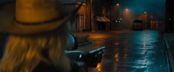 Movie still from “Texas Chainsaw Massacre” (2022), directed by David Blue Garcia – A person riding a scooter on a wet street at night; Wide shot, Over the shoulder angle