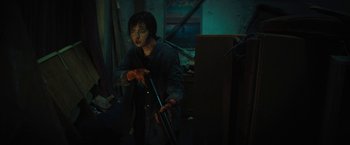 Movie still from “Texas Chainsaw Massacre” (2022), directed by David Blue Garcia – A person holding a stick in a dark room; Medium shot, High angle