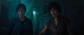 Movie still from “Texas Chainsaw Massacre” (2022), directed by David Blue Garcia – A woman in a brown shirt is standing next to a man in a brown shirt; Medium shot, Over the shoulder angle