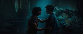 Movie still from “Texas Chainsaw Massacre” (2022), directed by David Blue Garcia – Two people standing next to each other in a dark room; Medium shot, High angle