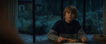 Movie still from “The Adam Project” (2022), directed by Shawn Levy – A boy sitting at a table with a slice of pizza; Medium shot, Over the shoulder angle