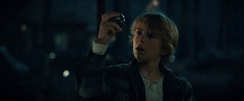 Movie still from “The Adam Project” (2022), directed by Shawn Levy – A young boy holding a cell phone up to his face; Close Up shot, Low angle