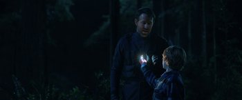Movie still from “The Adam Project” (2022), directed by Shawn Levy – A man and a boy are looking at a flashlight in the dark; Medium shot, Over the shoulder angle