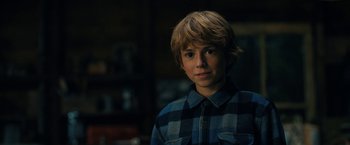 Movie still from “The Adam Project” (2022), directed by Shawn Levy – A young boy in a blue and black shirt; Close Up shot, Over the shoulder angle
